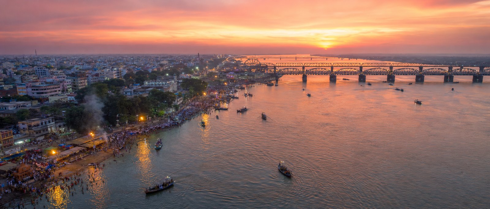 The Godavari at sunset, boats crossing beneath the Rajahmundry bridges
